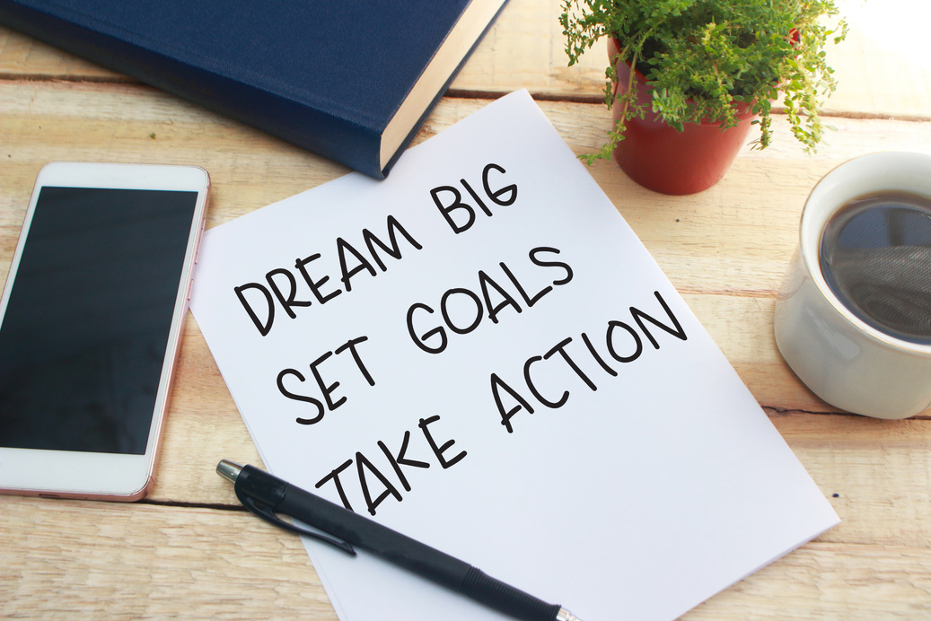 a piece of paper that had dream big, set goals, take action written on it. 