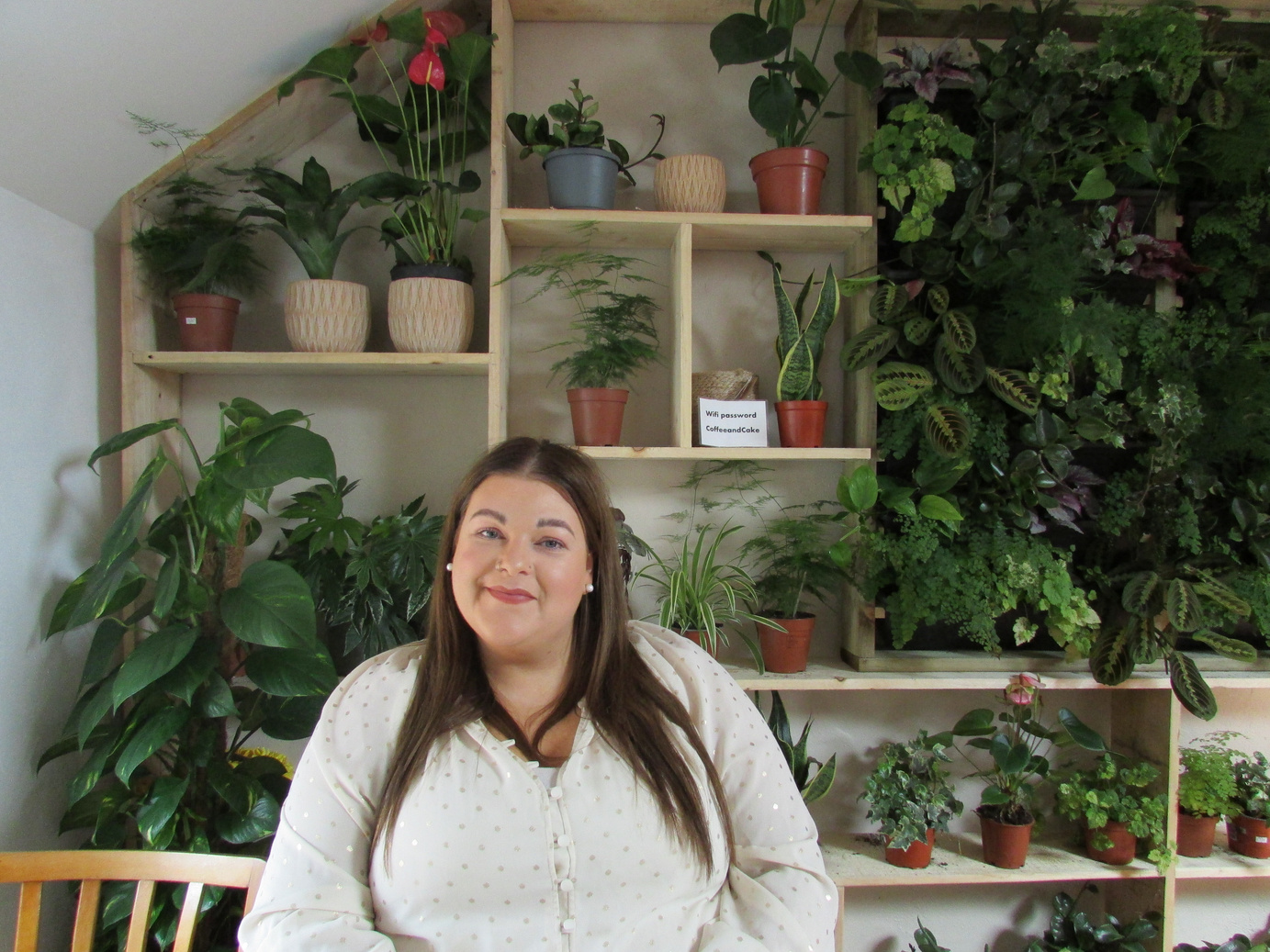 This is a picture of me sitting in front of a heart shaped display of plants